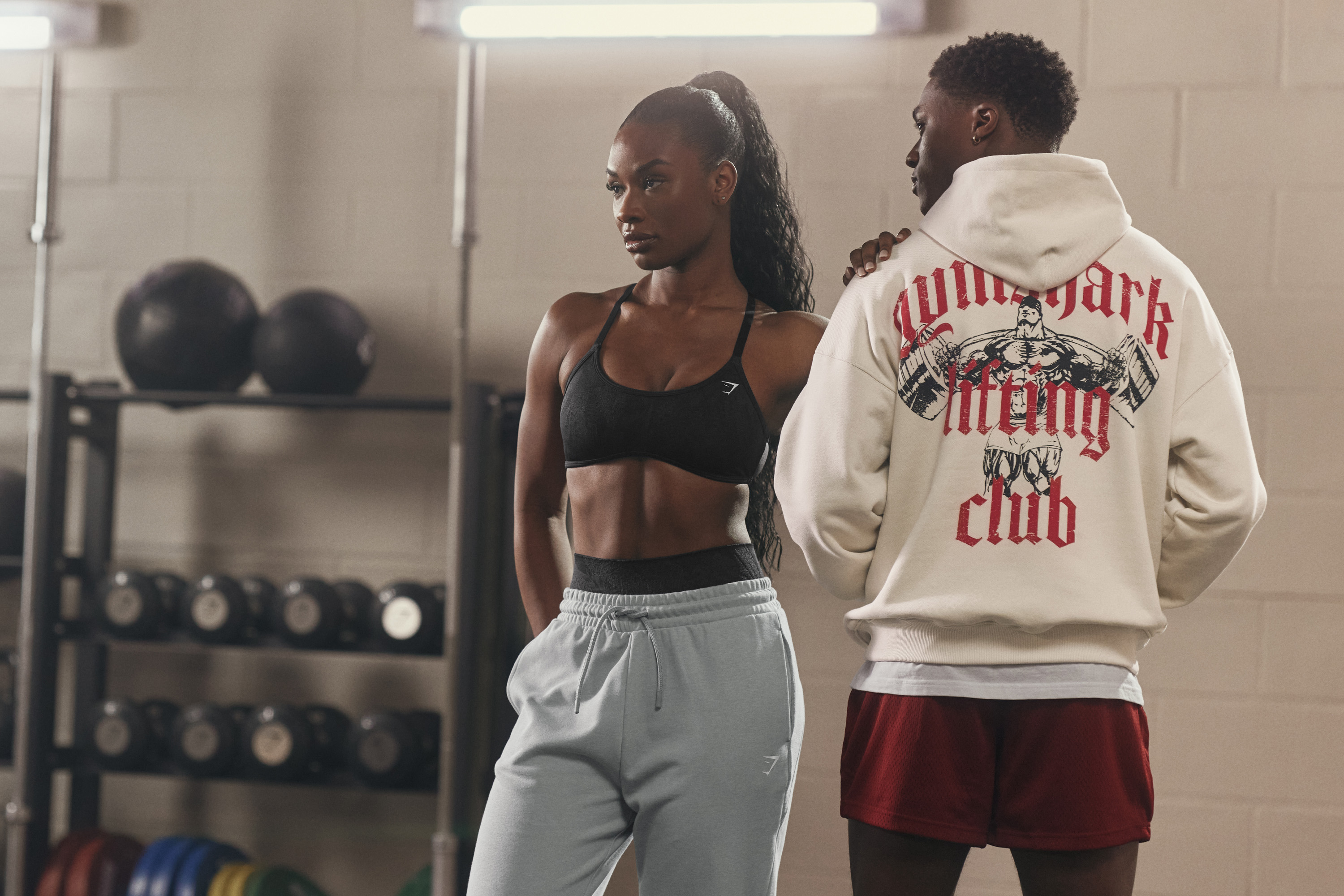 A woman and a man wearing Gymshark in a gym.